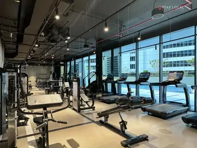 a gym with several treadmills and cardio machines at Experience Iconic Burj Khalifa Views from Your Cozy Getaway with Pool in Dubai
