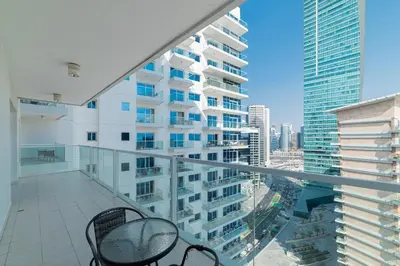 a balcony with two chairs and a view of a building at Elegant 1BR with Balcony & Views in Business Bay in Dubai