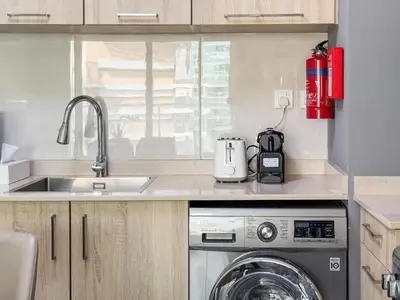 a kitchen with a sink and a washing machine at Elegant 1BR with Balcony & Views in Business Bay in Dubai