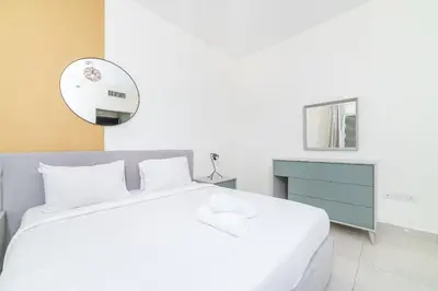 a bedroom with a white bed and a blue dresser at Luxurious 1-BR with Balcony & Views Business Bay in Dubai