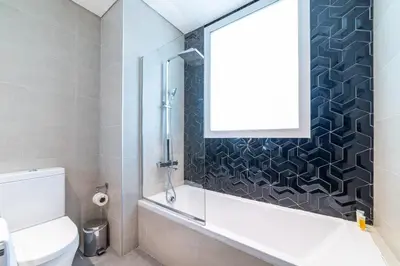 a bathroom with a shower and a toilet and a window at Luxurious 1-BR with Balcony & Views Business Bay in Dubai