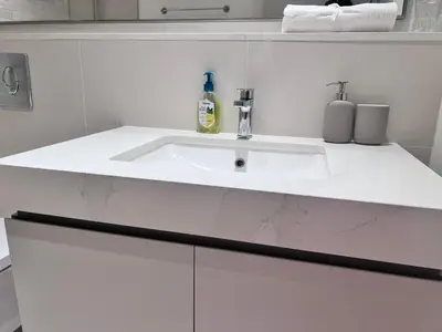 a white bathroom with a sink in a room at A Luxurious 2 Bedroom Emaar Beachfront Apartment in Palm Jumeirah in Dubai