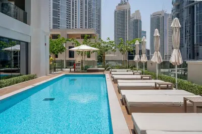 a swimming pool with lounge chairs and umbrellas at GuestReady - Charming retreat in Downtown Dubai in Dubai