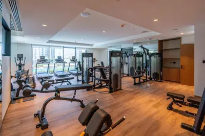 a gym with a lot of treadmills and machines at GuestReady - Charming retreat in Downtown Dubai in Dubai