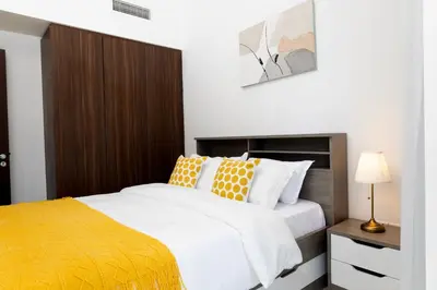a bedroom with a bed with orange and white pillows at Cozy 1BR Apartment with Water View Business Bay in Dubai