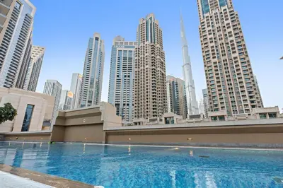 a large swimming pool in a city with tall buildings at Walk to Dubai Mall 2BR Apartment with Balcony and Pool in Dubai