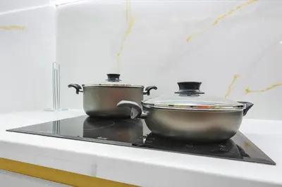 two pots sitting on top of a stove at Walk to Dubai Mall 2BR Apartment with Balcony and Pool in Dubai