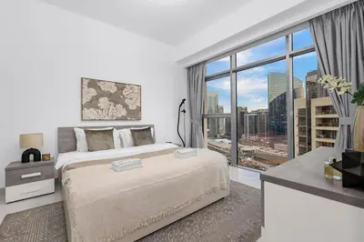 a bedroom with a large bed and a large window at FIRST CLASS 1BR Panoramic City View in Dubai