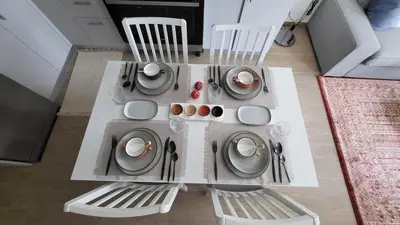 a white table with chairs and plates and silverware at Modern 2BR -5MIN to Metro & Festival Mall- 1211 in Dubai