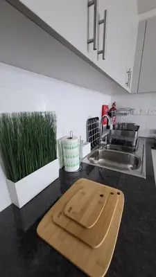 a wooden cutting board sitting on a kitchen counter at Modern 2BR -5MIN to Metro & Festival Mall- 1211 in Dubai