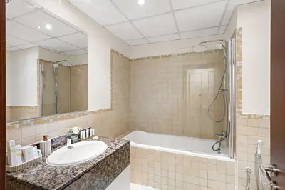 a bathroom with a tub and a sink at Luxe 2BR with Marina View in JBR and Walk to the Beach in Dubai