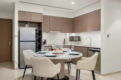 a kitchen with a table and chairs and a refrigerator at FIRST CLASS 2BR Incredible Burj Khalifa View in Dubai