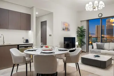 a kitchen and living room with a table and chairs at FIRST CLASS 2BR Incredible Burj Khalifa View in Dubai