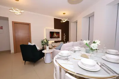 a dining room with a table with white dishes on it at Lux 2 Bed in Downtown Dubai w Dubai Mall Access in Dubai