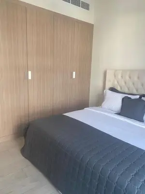 a bedroom with a large bed and wooden cabinets at furnished one bedroom huge terrace in Dubai