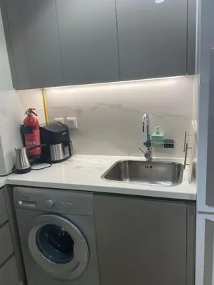 a kitchen with a sink and a washing machine at furnished one bedroom huge terrace in Dubai