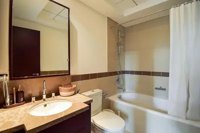 a bathroom with a toilet and a sink and a tub at Luxury Escapes - Modern 3BR Apt Stylish, Spacious and Comfortable in Dubai