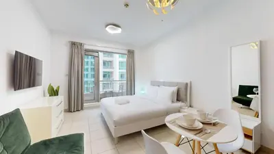 a white bedroom with a bed and a table and chairs at BLVD Central 2 - Studio Apartment in Downtown in Dubai