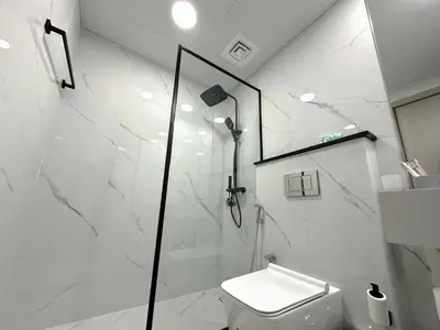 a white bathroom with a shower and a toilet at Dubai Marina - 1BHK Fancy Apartment in Dubai