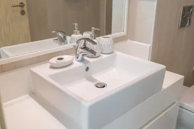 a white sink in a bathroom with a mirror at Lavish 3BR Apartment with Pool Access in Al Bateen in Dubai