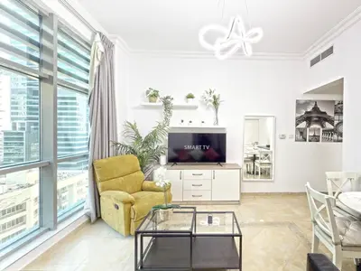 a living room with a tv and a yellow chair at One BedRoom near Beach and Metro in Dubai Marina Z1011 in Dubai