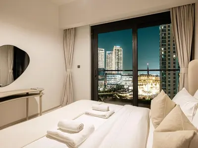 a white bedroom with a view of a city at Act Tower Suites by Prestige Nest in Dubai