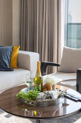 a table with a tray of grapes and a bottle of wine at Frank Porter - Nobles Tower in Dubai