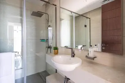 a bathroom with a sink and a glass shower at Frank Porter - Nobles Tower in Dubai
