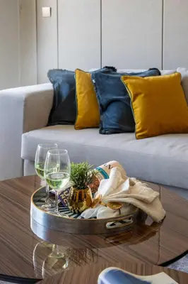 a coffee table with glasses of wine on a couch at Frank Porter - Nobles Tower in Dubai