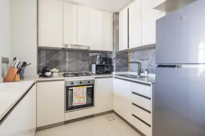 a kitchen with white cabinets and a stainless steel oven at Frank Porter - Nobles Tower in Dubai