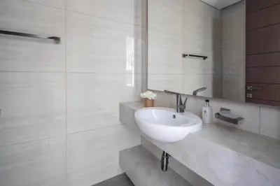 a bathroom with a white sink and a mirror at Frank Porter - Nobles Tower in Dubai