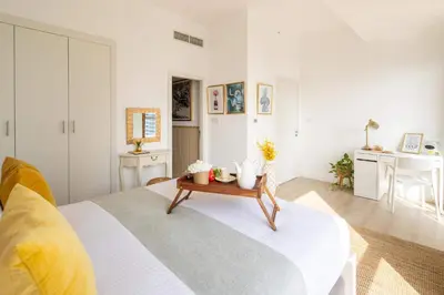 a bedroom with a bed with a table on it at Frank Porter - Bahar 6 in Dubai