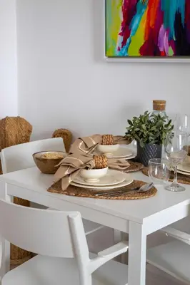 a white dining room table with a thanksgivinggiving table runner and a white table at Frank Porter - Bahar 6 in Dubai