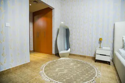 a bathroom with a toilet and a door with a rug at High Class 1bhk Business bay Marasi Drive Dubai in Dubai
