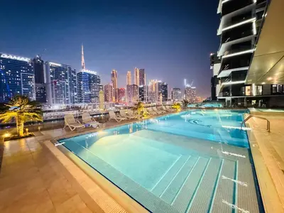 a large swimming pool with a city skyline at night at High Class 1bhk Business bay Marasi Drive Dubai in Dubai