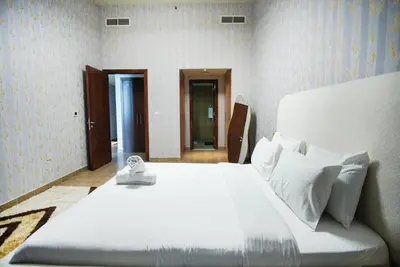 a bedroom with a large white bed with a clock on it at High Class 1bhk Business bay Marasi Drive Dubai in Dubai