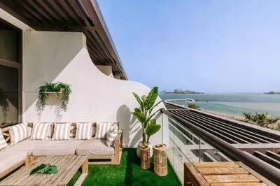 a balcony with a couch and a view of the ocean at Beachfront Bliss on the Palm Jumeirah in Dubai