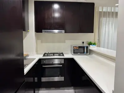 a kitchen with a stove and a microwave at Lala Land Homes - Magnificent 1 Br in Business Bay in Dubai