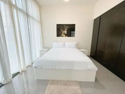 a white bedroom with a large bed with white sheets at Lala Land Homes - Magnificent 1 Br in Business Bay in Dubai