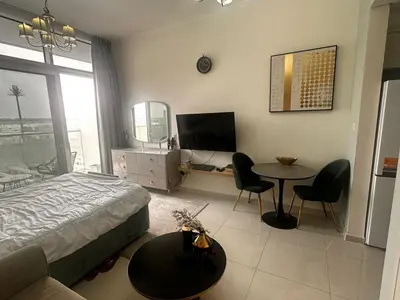 a bedroom with a bed and a table and chairs at Damac Hills in Dubai