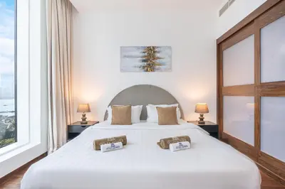 a bedroom with a large white bed with two pillows at Palm Home next to Nakheel Mall with Private Beach in Dubai
