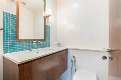 a bathroom with a sink and a toilet and a mirror at Palm Home next to Nakheel Mall with Private Beach in Dubai