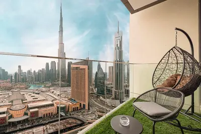 a chair on a balcony with a view of a city at High-Floor Luxe 2BR Stunning Burj Khalifa & Fountain Views Direct Dubai Mall Access in Dubai
