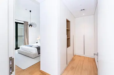a bedroom with white walls and a bed in a room at Escape24 Luxury 2BR Sea View with Beach Access in La Mer in Dubai