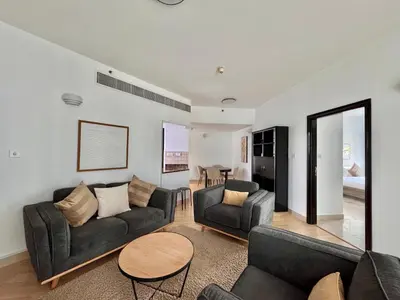 a living room with two couches and a table at 2 Bed Apartment in La Riviera Tower, Dubai Marina near Metro and Mall, 12-min walk to JBR Beach! in Dubai