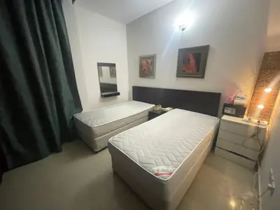 a room with two beds and a bedskirts at Room In Barsha Heights in Dubai