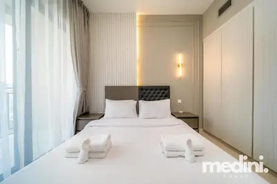 a bedroom with a large white bed with two white towels at New Listing - Sauna - Gym Pool - Business Bay in Dubai