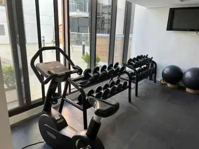 a row of exercise machines in a gym at Jumeirah Village Circle JVC One bedroom Luxurious Apartment in Dubai