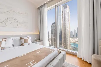 a bedroom with a large bed and a large window at Luxurious 4BR, Burj Khalifa & full fountain view, Downtown Dubai in Dubai