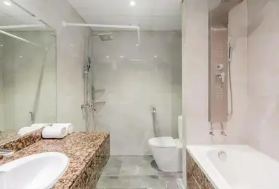 a bathroom with two sinks and a toilet and a shower at AHLAN Dubai Marina JBR in Dubai